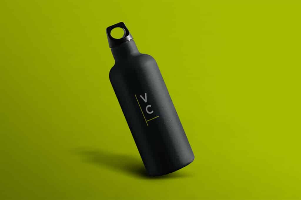 A matte black water bottle with a handle and the letters "VC" printed vertically in yellow, placed against a solid lime green background.