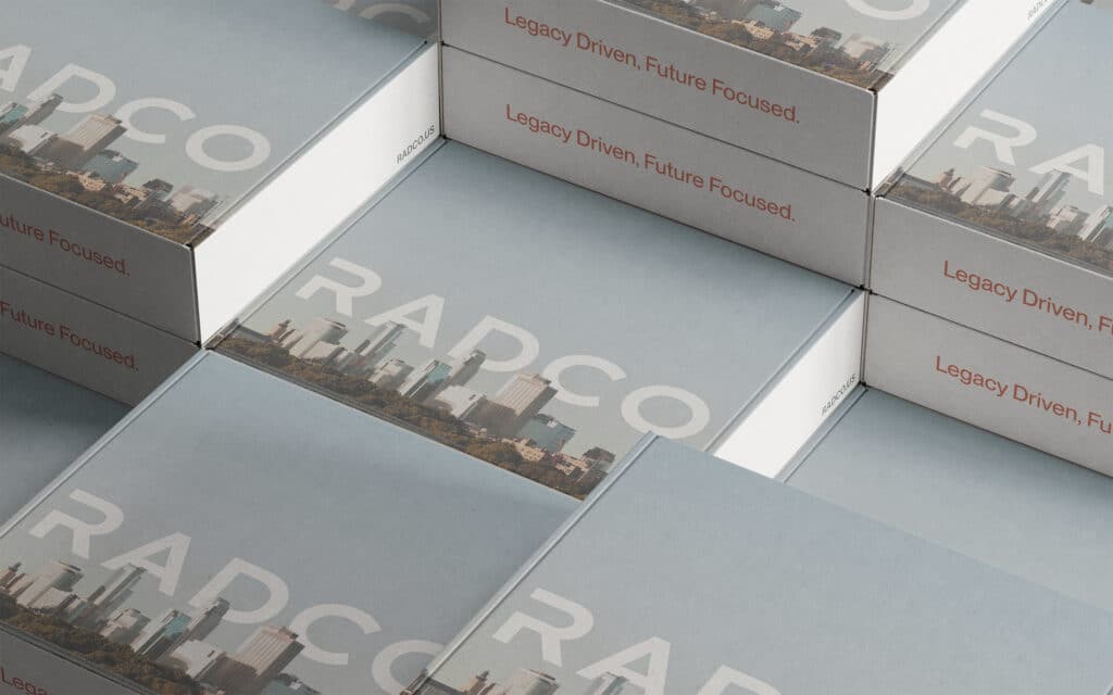 Stacked boxes with "RADCO" and "Legacy Driven, Future Focused" printed on them, featuring an image of a city skyline.