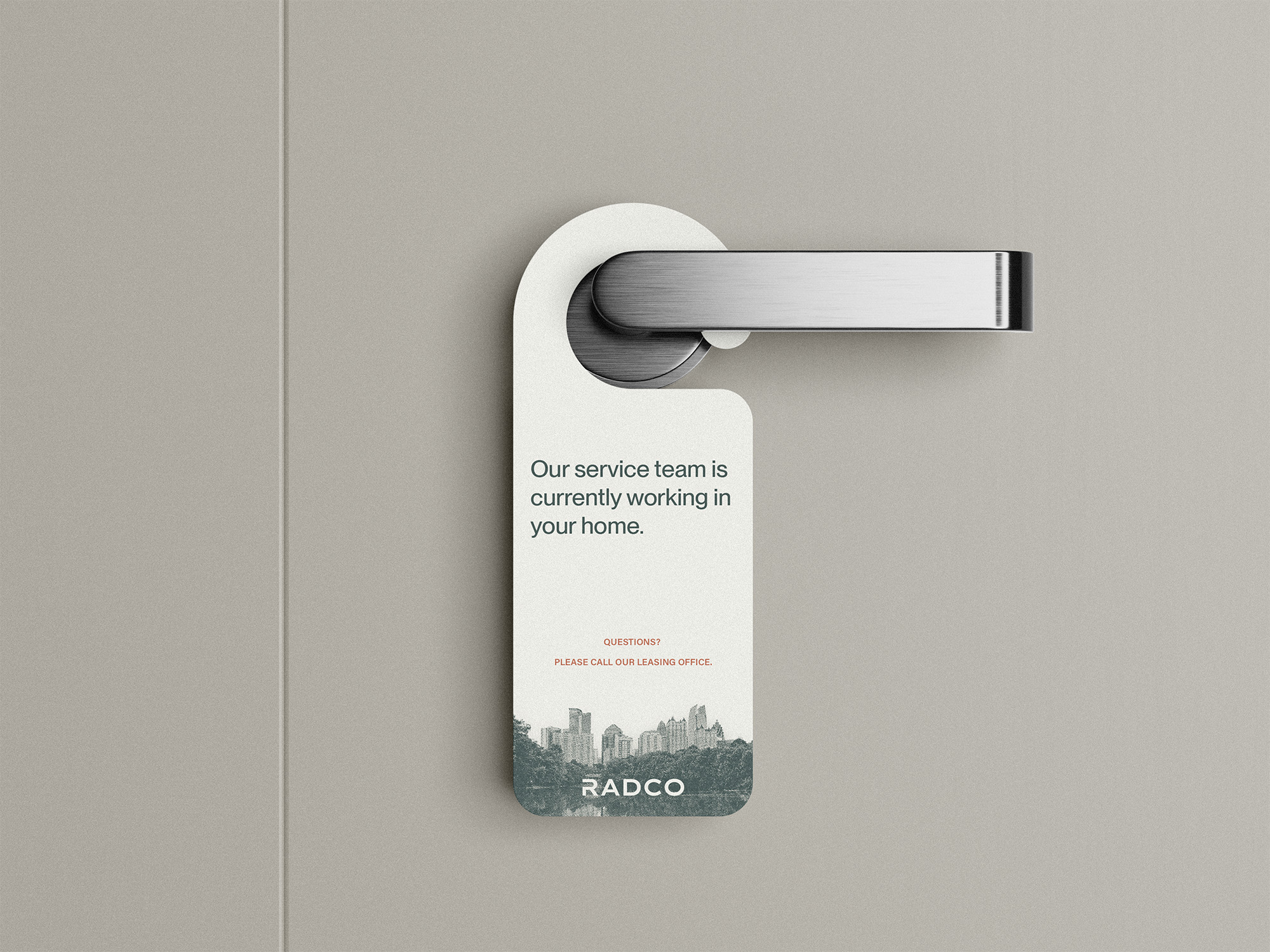 Door with a silver handle featuring a sign that reads, "Our service team is currently working in your home.