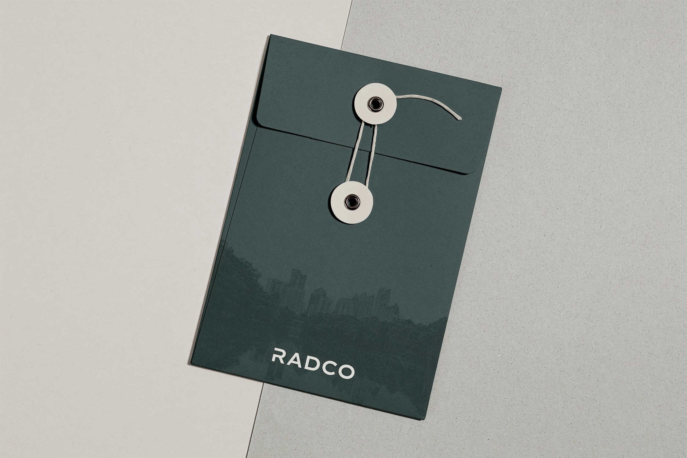 A dark green string-tied envelope labeled "RADCO" on a two-toned background.