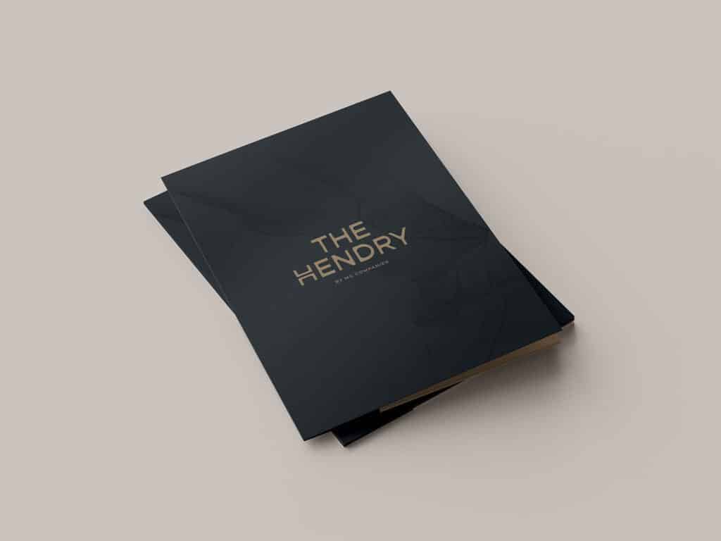 A black folder with "The Hendry" and "1044 W. Cornelia" in gold text on the front, placed on a plain surface.